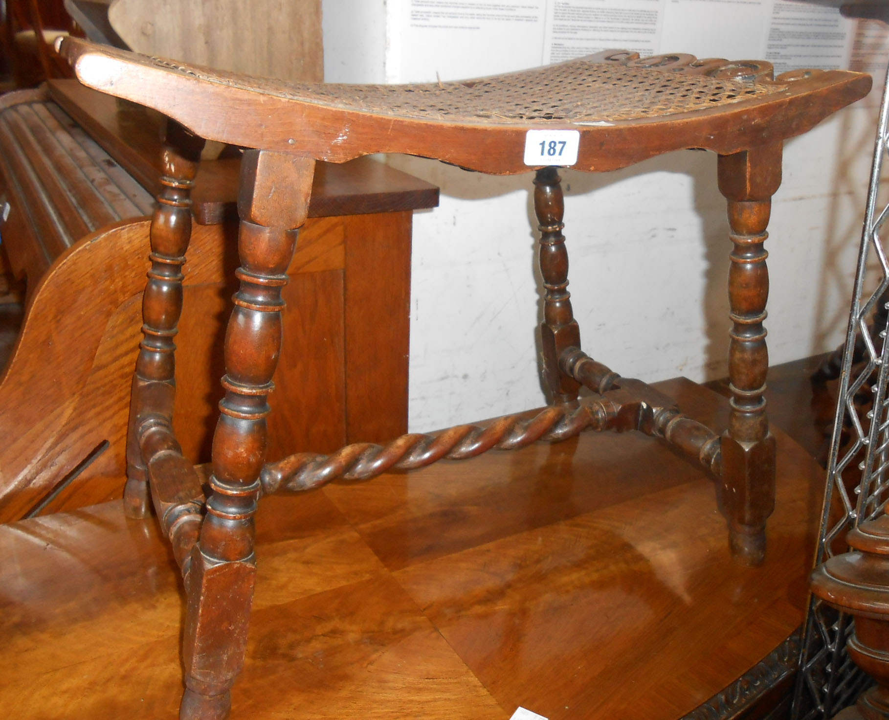 A mahogany dressing stool with curved seat and woven rattan panel, set on barley twist supports -