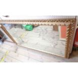 A modern ornate gilt framed wall mirror with internal etched and engraved decoration depicting