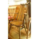 A mid-Century Ercol elm stick-back elbow chair with solid moulded seat, set on tapered supports -
