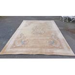 A large Chinese washed wool rug with stylised dragon decoration and repeat key border
