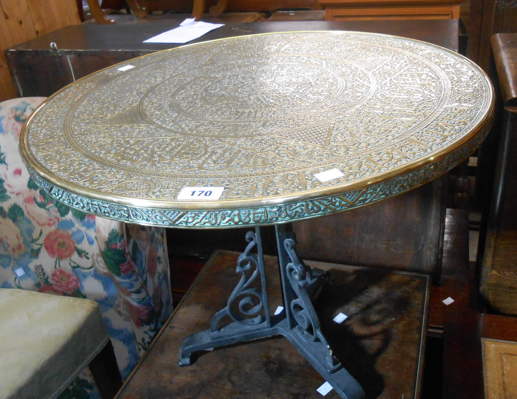 A 60cm diameter 20th Century Islamic tray style table top, set on a painted cast iron trefoil base