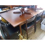 A retro G-Plan style teak and mixed wood extending dining table with pull-out end supports and two