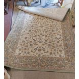 A machine made Belgian rug with central Persian flowerhead pattern on cream ground with decorative