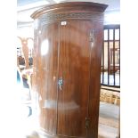 A 72 cm antique mahogany wall hanging bow front corner cabinet with blind fretwork decoration to top