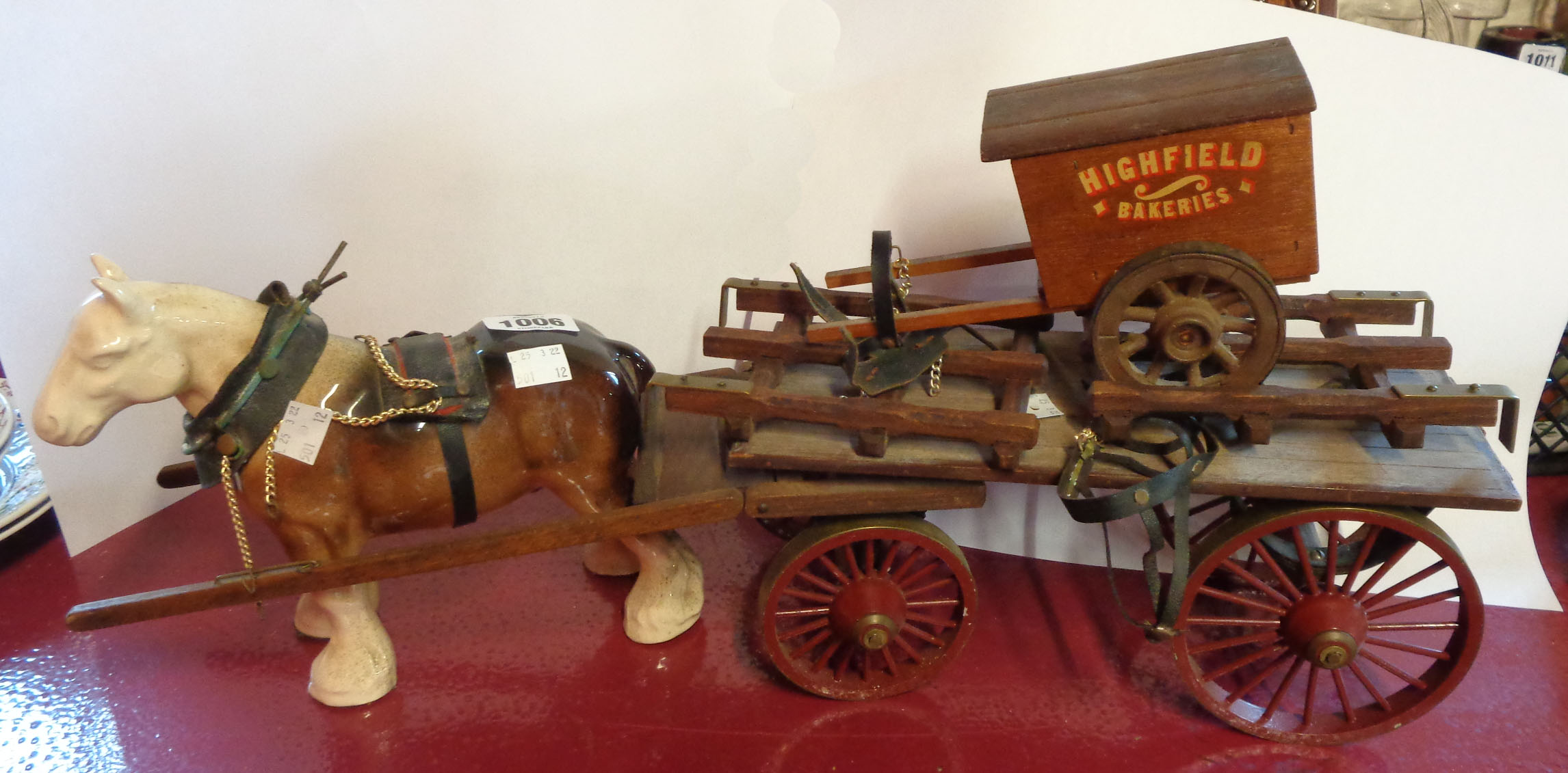 A vintage ceramic cart horse with wooden cart and associated bakers' cart