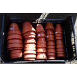 A crate containing a quantity of small terracotta garden pots