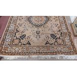 A machine made Belgian rug with central floral medallion and geometric border on buff ground