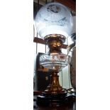 A Victorian oil lamp with cut sided glass reservoir, brass pedestal stem and opaque ceramic foot -