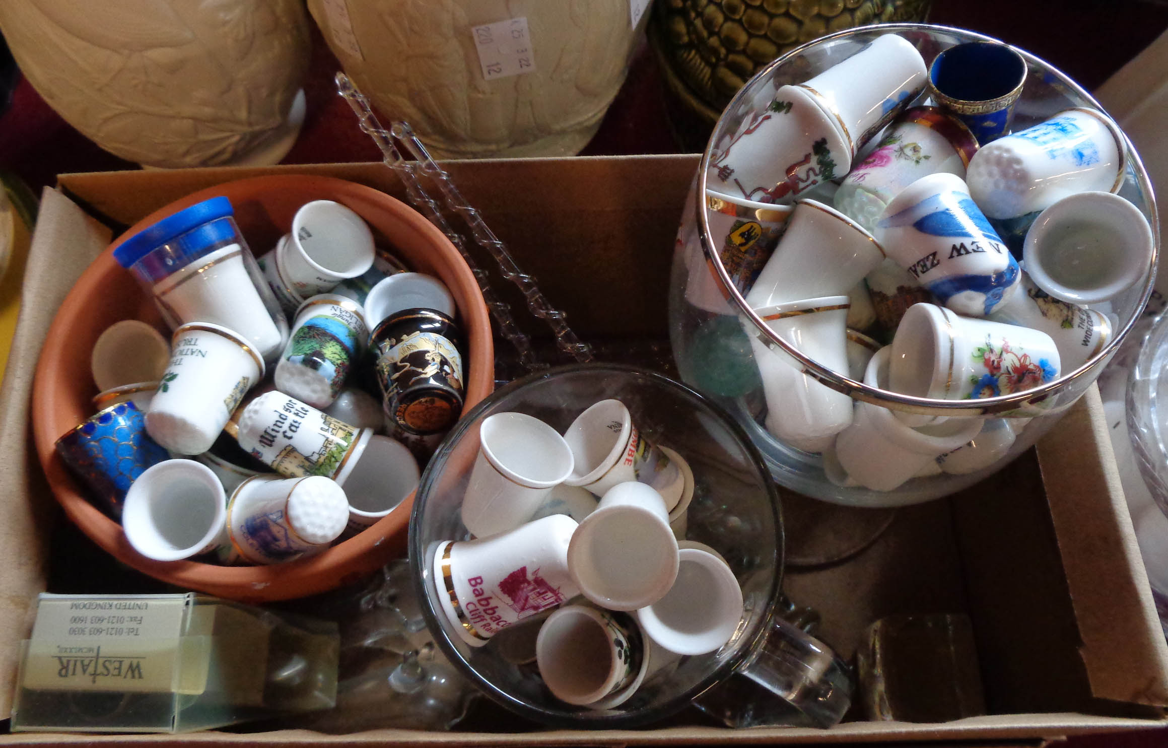 A box containing a large quantity of ceramic and other collectable thimbles, glassware, etc.