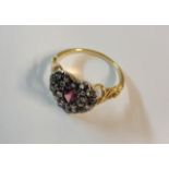 An unmarked yellow metal ring with heart shaped old cut diamond cluster panel, with central oval