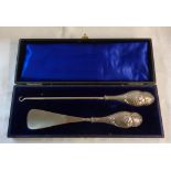 A cased Chester silver handled button hook and shoehorn with cherub decoration