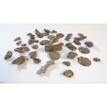 A collection of Chinese white metal applique charms and a lock pattern pendant, etc.