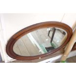 An early 20th Century mahogany framed bevelled oval wall mirror