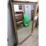 A 20th Century antique gilt gesso style bevelled oblong wall mirror - 1.4m X 90cm