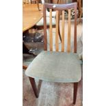 A set of four retro G-Plan teak framed lathe back dining chairs with upholstered seats, set on