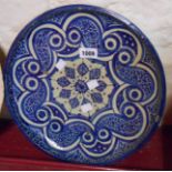 An old Middle Eastern tin glazed charger with blue painted decoration