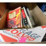 A box containing a selection of books and publications including 'The Who, Tommy', 'Brave Deeds of