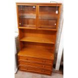 An 87cm retro G-Plan teak effect two part wall unit with glazed top section over a base with three