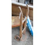 A small old sack truck with wooden frame, wrought iron bracket and cast iron wheels