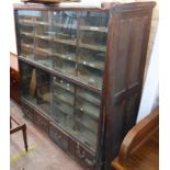 A 1.56m vintage stained mixed wood haberdashery unit with flights of slides enclosed by glass