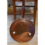An antique copper warming pan with turned wooden handle