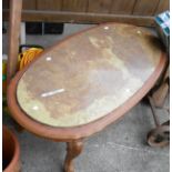 A vintage wooden coffee table with large oval onyx panel inset top set on cabriole legs - one leg