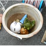 A large garden planter containing a quantity of ceramic and other figurines