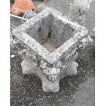 A concrete garden planter of square urn form with lion supports