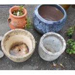 Four assorted garden planters including terracotta strawberry pot and Cotswold range barrel form