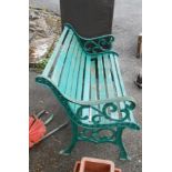 A 20th Century garden bench with decorative scroll cast iron ends and wooden slatted seat - one slat