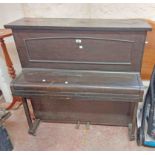 A 1.1m antique stained oak cased cottage piano with wooden frame and five and half octave keyboard -