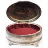A 14cm silver oval ring box with hinged lid, material lining and reeded scroll feet - one slightly