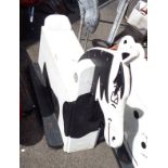 A vintage wooden child's fairground ride seat in the form of a black and white painted horse