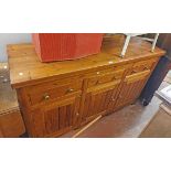 A 1.63m stained pine dresser base in the antique style with thick top, three frieze drawers and
