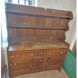 A 1.3m early 20th Century stained oak two part dresser with two shelf open plate rack over a base