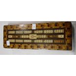 An antique cribbage board with allover marquetry work decoration with inset bone panels and a