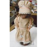 An old French porcelain headed doll with jointed composition body - on stand