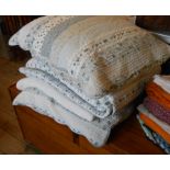 A quilted bedspread and two matching cushions