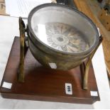 An early 19th Century ship's gimbal compass with paper label to dial and mounted on later wooden