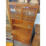 An 87cm retro G-Plan teak effect two part wall unit with glazed top section over a base with three