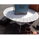 A large cast aluminium garden table of circular form with white painted finish