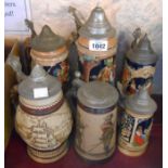 Six German pottery steins with lift-top metal lids and various decoration