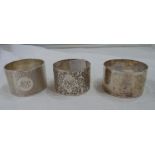 Three silver napkin rings comprising one plain and two others with engraved initials