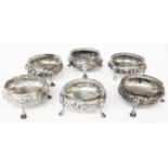 Six Victorian silver salts, all by Robert Harper, with similar embossed decoration, set on shell-