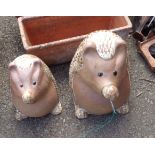 Two large ceramic garden statues depicting comical hedgehogs