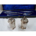 A pair of silver pepperettes with push-fit lids and embossed decoration - Sheffield, 1899 - sold