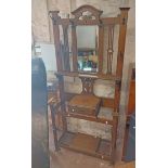A 95cm early 20th Century oak hallstand with central bevelled mirror, drawer and undertier with