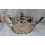 A silver elliptical teapot with hinged flip-top, perished ivory mounts and initials to cartouche -