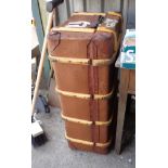 A vintage cane bound travelling trunk with weather proof canvas and applied travel labels from
