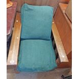 An early 20th Century oak show frame open armchair with slatted back and sides, green upholstery and